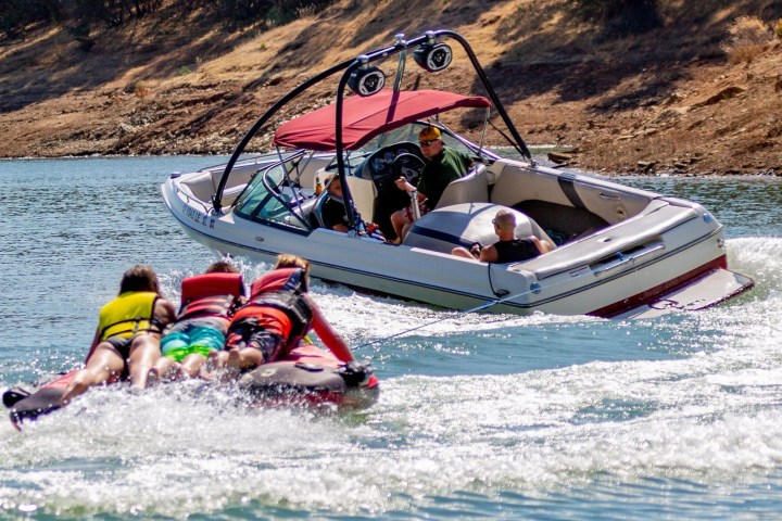 a man riding on the back of a boat in a body of water