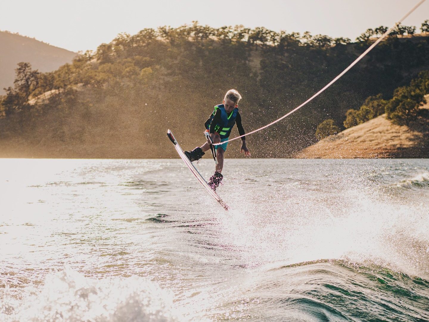 a man flying through the air while riding a wave in the ocean